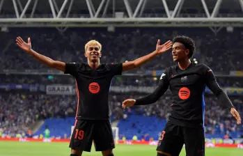 Lamine Yamal (izquierda) y Alejandro Balde, festejando el primer tanto del Barcelona que encaminó el título de LaLiga. FOTO: AFP