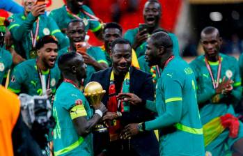 El técnico Pape Thiaw, junto a sus dirigidos y el trofeo durante la celebración del título ganado en la cancha ante Marruecos. FOTO GETTY 