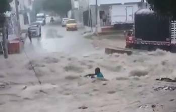 Momento en el que el hombre está siendo arrastrado por el arroyo que fue causado por las fuertes lluvias en toda la zona. FOTO: CAPTURA VIDEO REDES SOCIALES