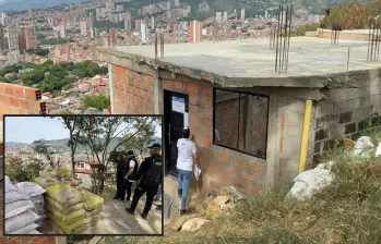 Adelante, parte del material que fue incautado y destruido por las autoridades. Atrás, una de las viviendas ilegales que se alzan en la zona. FOTO: Cortesía