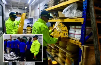 Adelante, los detenidos tras el operativo. Atrás, parte de las placas y del material para su fabricación incautado. FOTO: Cortesía
