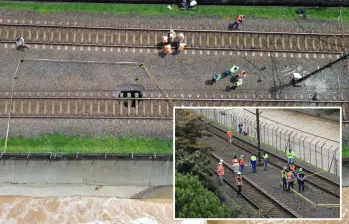 Adelante, obreros e ingenieros del Metro y de EPM evalúan la situación. Atrás, el enorme hueco que apareció en la vía férrea. FOTOS: Camilo Suárez.