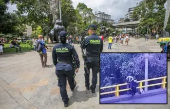 Adelante, momentos del rescate realizado por policías de Medellín. Atrás, un cudrante patrullando el Parque de Botero. Foto: Esneyder Gutiérrez