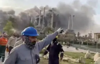 Los trabajadores evacúan el área alrededor de la refinería de petróleo Ras Tanura de Saudi Aramco mientras se eleva el humo luego de un reportado ataque con drones iraníes en Arabia Saudita. FOTO: Tomada de Al Jazeera.