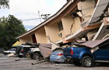Un edificio quedó casi completamente destruido después del terremoto, aplastando a los vehículos que estaban parqueados debajo. Foto: AFP.
