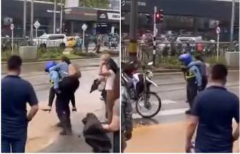 En las imágenes quedó evidenciado cómo el agente cargó a una mujer para que no se ensuciara y pudiera pasar la calle, haciendo esto, según testigos, con más personas en el lugar. FOTO: Captura video de redes sociales @FicoGutierrez