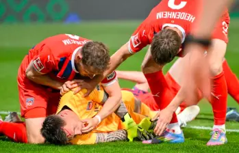 El impacto fue tan fuerte que Kevin Müller quedó tendido en el césped, desatando nerviosismo en el campo. FOTO: AFP