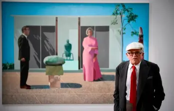 David Hockney murió a los 88 años. Aquí con una de sus pinturas Fred y Marcia Weisman, expuesta en París. FOTO AFP