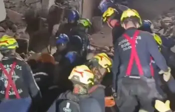Los Bomberos de Bogotá sacan a la persona rescatada en camilla. Foto: Captura de video.