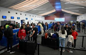 Los pasajeros se registran para sus vuelos en una de las carpas provisionales habilitadas para la reactivación de la operación comercial en el aeropuerto de Maiquetía-Simón Bolívar, que presta sus servicios a Caracas. Foto: AFP.