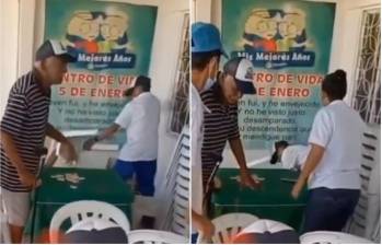 Mientras uno de los adultos mayores golpeaba con una silla de plástico blanca, el otro le tiraba patadas desde el suelo. FOTO: CAPTURA VIDEO CTV Barranquilla