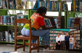Adelante, los directivos de las entidades que hicieron posible la entrega de las bibliotecas. Atrás ,imagen de referencia de una biblioteca pública. FOTO: Cortesía y Manuel Saldarriaga.