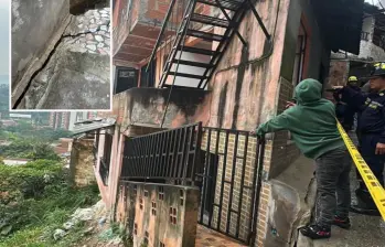 Adelante, una de las grietas que apareció en una de las viviendas afectadas. Atrás, el cierre de las edificaciones por parte de las autoridades. FOTO: Cortesía