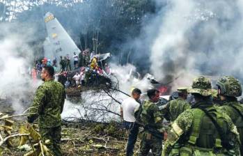 Personal militar y civil acude al sitio de la tragedia en medio de los escombros y el humo. FOTO: AFP