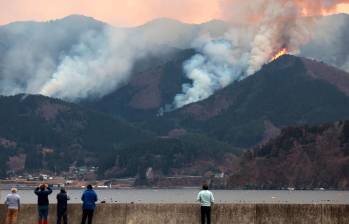 Las condiciones climáticas adversas, han dificultado los esfuerzos por controlar el incendio. A pesar de la intensa labor de los equipos de emergencia, el fuego sigue avanzando, amenazando a más comunidades y generando una situación crítica en la región. Foto: AFP