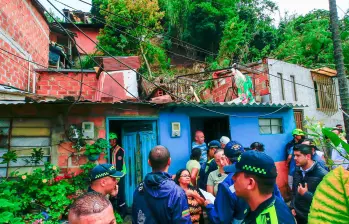 Autoridades y comunidad tratan de remover la tierra que cayó sobre la propiedad en el barrio La Unión, de Itagüí. FOTO: Camilo Suárez
