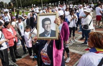 Una mujer sosteniendo un cuadro con el rostro de Miguel Uribe en la “Carrera por la Vida”, en respaldo a la salud del senador. FOTO: COLPRENSA