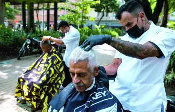 Con todos los implementos, ambos barberos motilan gratis a quien llega al Parque Bolívar. FOTO Julio Herrera.