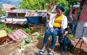 Marcelina Valencia está al lado de su perra, sentada en una silla, viendo cómo funcionarios de la Alcaldía tumban su vivienda y la de su hermano. FOTO: JULIO CÉSAR HERRERA