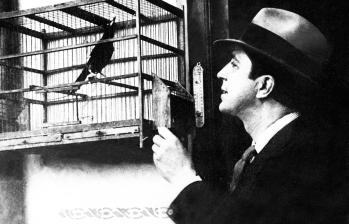 Foto tomada en 1930 muestra al cantante de tango observando un pájaro en una jaula. FOTO AFP