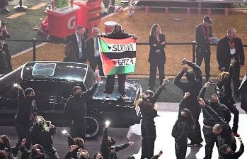 Hondeando la bandera, el hombre subió de sorpresa a un coche que hacía parte del espectáculo del medio tiempo del Super Bowl. FOTO: AFP