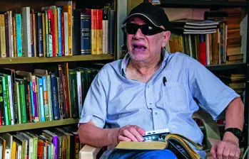 Hernán Castrillón fue víctima de una golpiza hace tres años que lo dejó prácticamente ciego. Aunque puede leer con una lupa electrónica, no puede salir de su casa. FOTO Julio Herrera