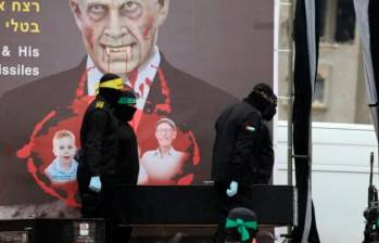 Hamás expuso los ataúdes de los rehenes delante de un gran cartel con la imagen del primer ministro israelí, Benjamin Netanyahu, presentado como un vampiro sediento de sangre. FOTO: AFP