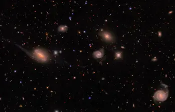 Imagen de DECam de un campo en la constelación austral de Lepus que muestra estrellas de la Vía Láctea (pequeños puntos de colores) y un grupo de galaxias (los objetos difusos de mayor tamaño) situado a unos 300 millones de años luz. FOTO Agencia SINC - Erin Sheldon