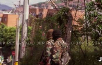 La foto que expuso la JEP durante la audiencia, muestra a dos hombres con camuflado militar, capuchas y fusiles terciados. FOTO: CORTESÍA JEP.