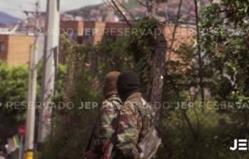 La foto que expuso la JEP durante la audiencia, muestra a dos hombres con camuflado militar, capuchas y fusiles terciados. FOTO: CORTESÍA JEP.