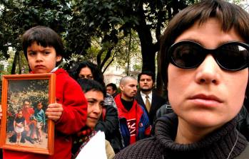 Un niño muestra la foto de un familiar desaparecido (i) junto a un grupo de manifestantes familiares de las víctimas de la dictadura de Agusto Pinochet en Chile. FOTO: EFE.