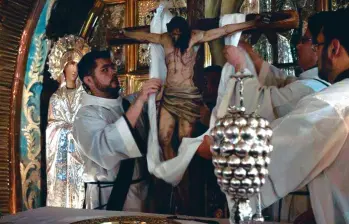 El Cristo del Silencio es puesto en la cruz por los frailes franciscanos. La pieza fue hecha por Santiago Ocampo Higuita. FOTO Cortesía.