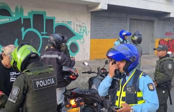 Uno de los agentes requisa a un moticiclista que transitaba por la zona mientras agentes de movilidad realizan controles. FOTO: Cortesía