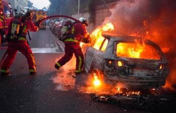 Más de 40 vehículos han sido quemados en los disturbios. FOTO: AFP.