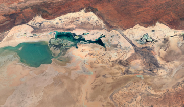 Vista aérea del paisaje desértico en Australia Occidental, capturada por Google Earth, donde contrastan las lagunas turquesa con las formaciones rocosas y los tonos ocres del terreno. FOTO cortesía Google Earth