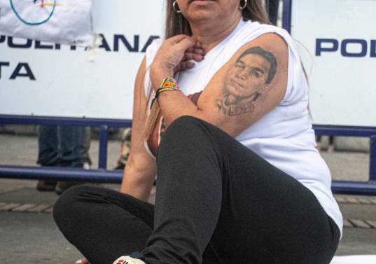 Beatriz Méndez, con los zapatos de su hijo y un tatuaje de su rostro, en la plaza de Bolívar durante el acto de excusas públicas el pasado 3 de octubre. Foto: Cortesía Paula Dpablos.
