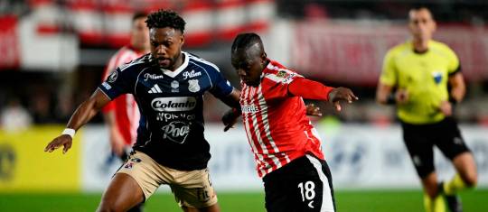 El lateral colombiano Léyser Chaverra, del DIM, y el extremo vallecaucano Edwuin Cetré, de Estudiantes, disputan un balón en el estadio de La Plata, en Argentina. Foto: AFP