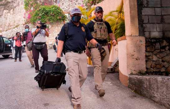 Tras varias horas en el interior de la vivienda, pasadas las 5:00 de la tarde comenzaron a salir miembros de la Policía Científica de Haití con diversas pruebas, todas empaquetadas en fundas plásticas o bolsas de papel, excepto un monitor de computadora. FOTO: EFE