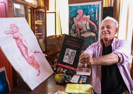 En su estudio, Fernando Rivillas sostiene un ejemplar de la biografía de Julio Cortázar que publicó hace poco. Foto: Manuel Saldarriaga