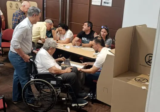 Un ciudadano en silla de ruedas llega al puesto de votación de San Diego, en Medellín, pese a que este fue trasladado al piso 11 de un edificio con pocos ascensores y difícil acceso. Foto: EL COLOMBIANO