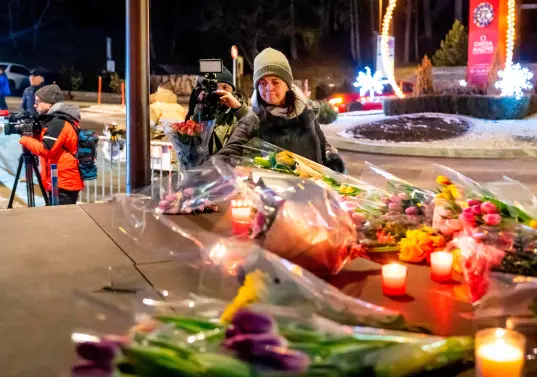 Una mujer pone flores cerca del lugar donde un incendio arrasó un bar abarrotado durante las celebraciones de Nochevieja en la ciudad de Crans-Montana. FOTO: AFP