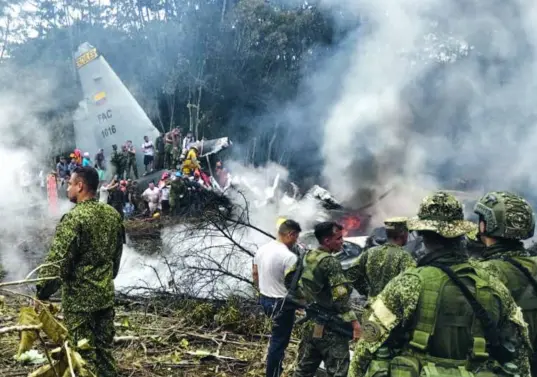 Personal militar y civil acude al sitio de la tragedia en medio de los escombros y el humo. FOTO: AFP