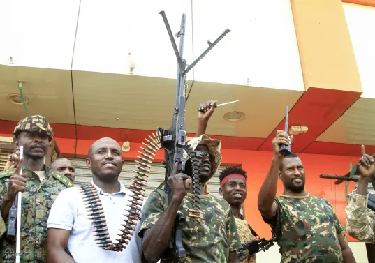 Un hombre posa con soldados del ejército sudanés en Salha, al sur de Omdurman, un día después de haber recuperado la zona de manos de las fuerzas paramilitares de Apoyo Rápido (RSF), el 21 de mayo de 2025. Desde su estallido en 2023, Sudán ha sido devastado por la guerra entre las RSF y el ejército, alimentada por intereses regionales contrapuestos que incluyen a los Emiratos Árabes Unidos, Egipto, Arabia Saudita e Irán. Mercenarios extranjeros han aparecido en ambos bandos del conflicto. (Foto de Ebrahim Hamid / AFP)