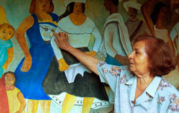 La pintora bellanita mostrando uno de sus murales. Foto: Archivo. 