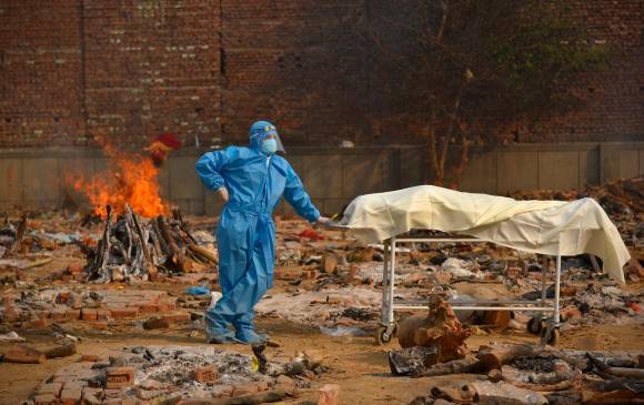 Ante falta de capacidad de los crematorios, las autoridades han tenido que incinerar los cuerpos en piras de fuego en la calle a plena vista del público. FOTO EFE