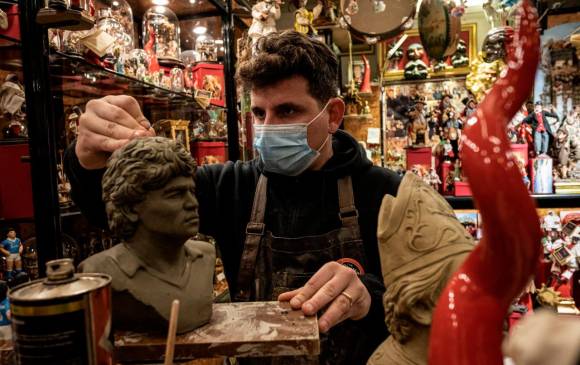 Un joven artesano de San Gregorio Armeno (Maestro de la Natividad) trabaja en un busto de Maradona en su taller. Foto: Getty Images.