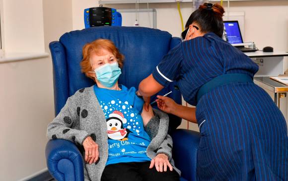 Margaret Keenan, de 90 años de edad, fue la primera mujer en vacunarse en el Reino Unido de manera oficial. La lucha de los gobiernos por adquirir las dosis para atender a su población pasa por limitantes económicas y de poder de negociación. FOTO Getty Images