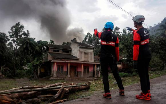 Rescatistas cargan el cuerpo de una de las víctimas de la reciente erupción del volcán de Indonesia. FOTO EFE.