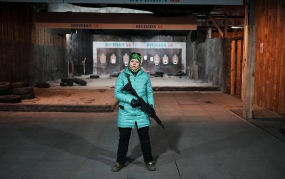 Una mujer ucraniana sostiene un arma en un centro de entrenamiento de tiro en la base militar en el pueblo portuario de Burlacha Barlka, a unos 20 kilómetros de Odesa. FOTO: EFE. 