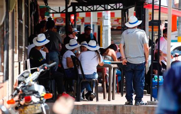 Hombres de sombrero esperan los resultados en una salsamentaria de Calatrava y entregan propaganda electoral. FOTO EDWIN BUSTAMANTE
